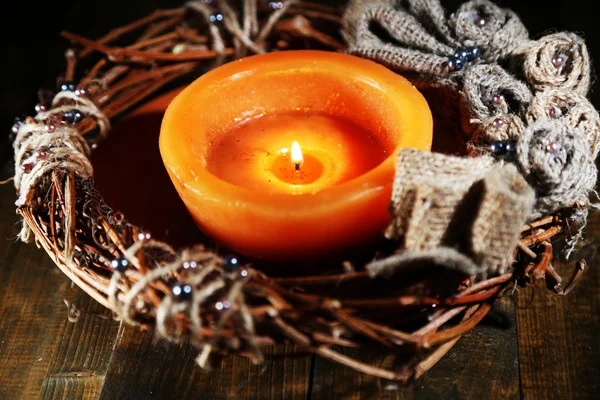 Vela ardiente con corona de Navidad sobre fondo de madera — Foto de Stock