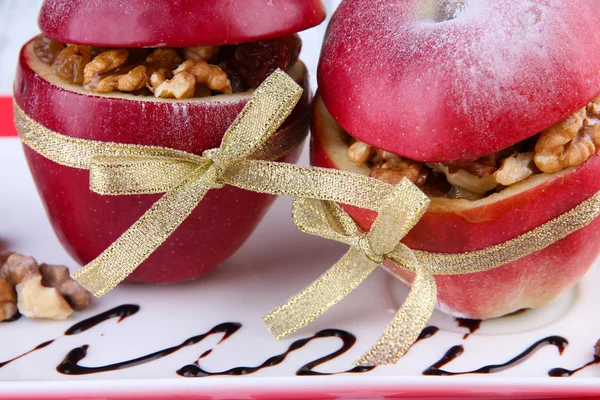 Фаршированные яблоки с орехами и изюмом на тарелке — стоковое фото