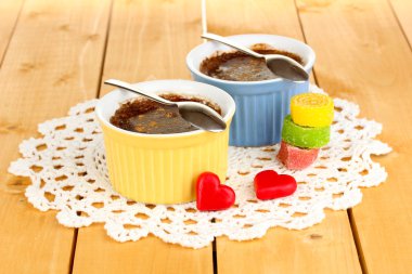 Chocolate pudding in bowls for baking on wooden table clipart