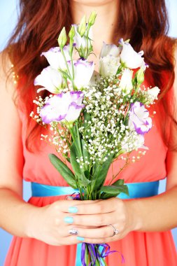 buket, mavi arka plan üzerinde tutan kadın yakın çekim