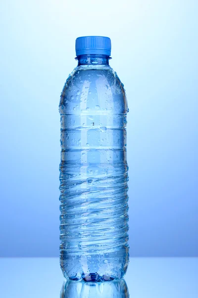 Bottiglia di plastica di acqua su sfondo blu — Foto Stock