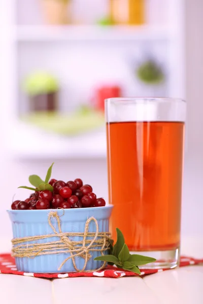 Bicchiere di succo di mirtillo e mirtilli rossi maturi in ciotola sul tavolo — Foto Stock