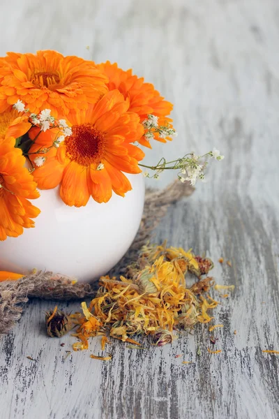 Calendula flowers in vase on wooden background — Stock Photo, Image