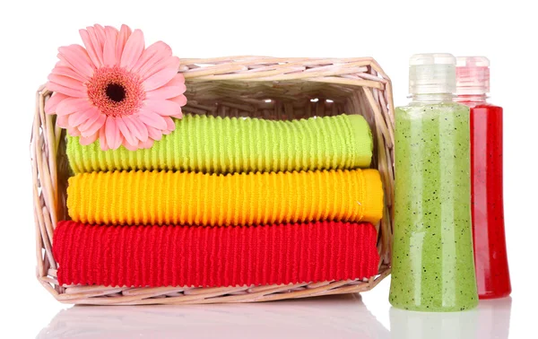 Toallas de colores en la cesta y botellas de cosméticos aislados en blanco —  Fotos de Stock