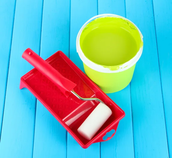 Set para pintar: maceta de pintura, rodillo de pintura sobre mesa de madera azul — Foto de Stock