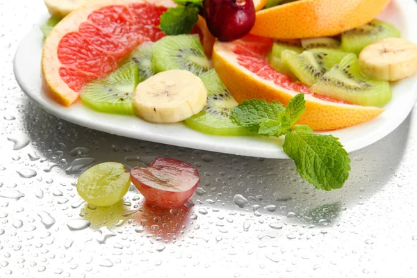 Surtido de frutas en rodajas en plato con gotas —  Fotos de Stock