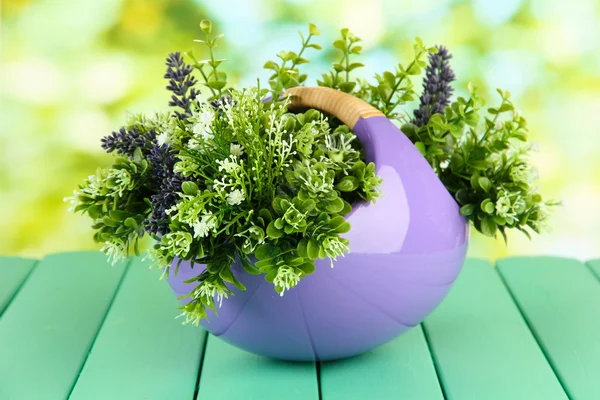 Pot met bloemen op een houten tafel op de achtergrond van de natuur — Stockfoto