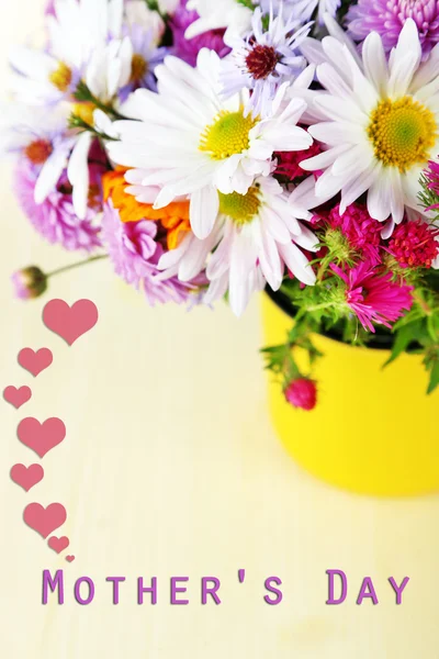 Blommor i mugg på träbord — Stockfoto