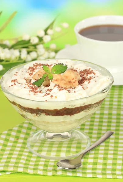 Deliciosa sobremesa com banana e caramelo na mesa em fundo brilhante — Fotografia de Stock