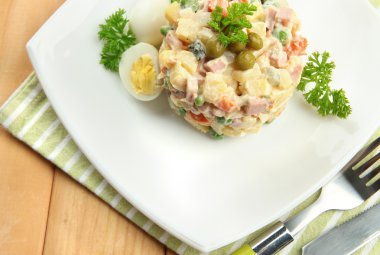 Rus salatası geleneksel ahşap arka plan üzerinde renkli peçete üzerinde olivier