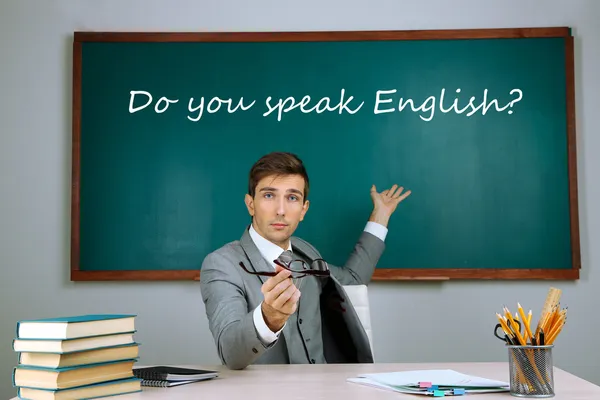 Young teacher sitting in school classroom — Stock Photo, Image