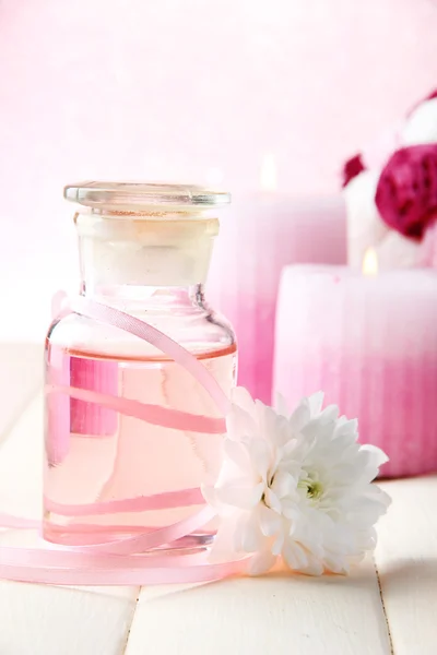 Glazen flesje met kleur essentie, op roze achtergrond — Stockfoto