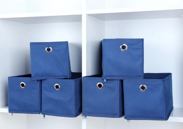 Modrý textilní boxy v bílé police — Stock fotografie