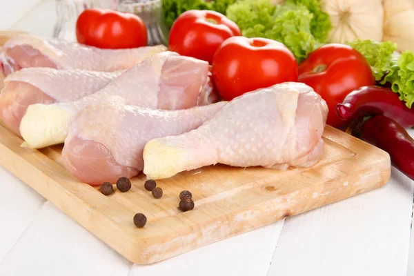 Raw chicken legs on wooden board close up — Stock Photo, Image