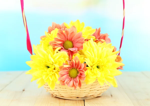 Chrysanthemenblüten im Korb auf Holztisch vor natürlichem Hintergrund — Stockfoto