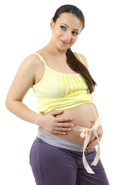 Jonge zwangere vrouw met beige strik op buik geïsoleerd op wit — Stockfoto
