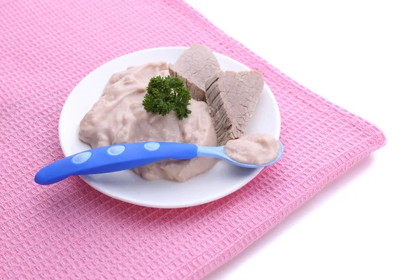 Мясная паста для кормления младенцев, на тарелке, на цветной салфетке, изолированная на белом — стоковое фото