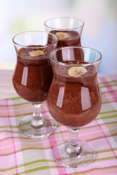 Coquetéis com banana e chocolate na mesa em fundo claro — Fotografia de Stock