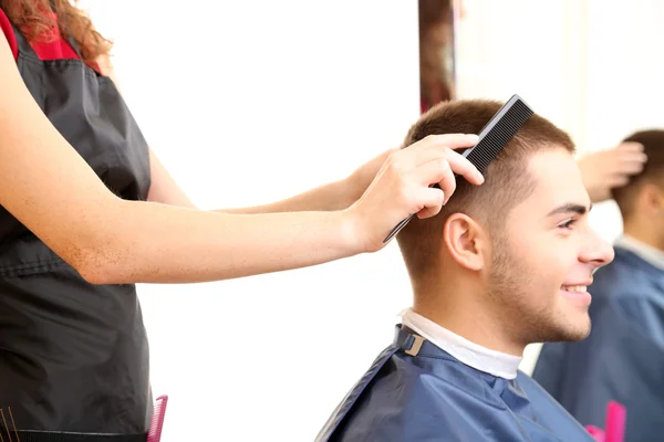 Piękna dziewczyna fryzjer cięcia facet w gabinecie kosmetycznym — Zdjęcie stockowe
