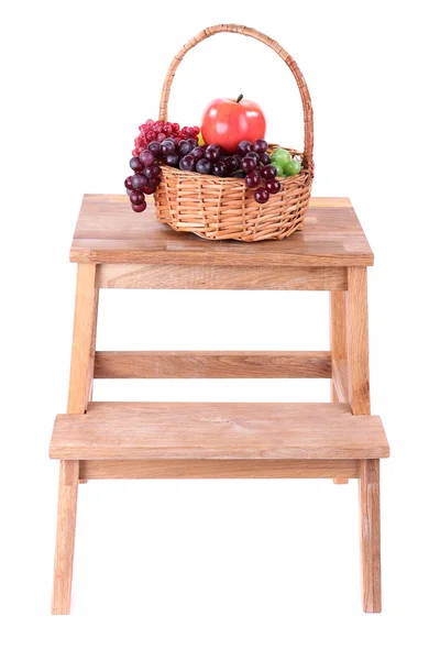 Wicker basket with fruits, on small wooden ladder, isolated on white — Stock Photo, Image