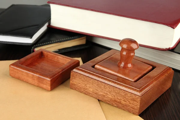 Ξύλινη σφραγίδα με τα σημειωματάρια και βιβλία στο τραπέζι — Φωτογραφία Αρχείου