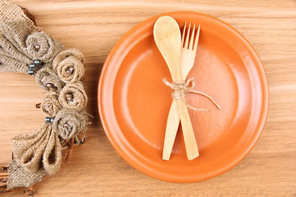 Apparecchio da tavolo rustico con piastra, forchetta e cucchiaio, su tavolo in legno — Foto Stock