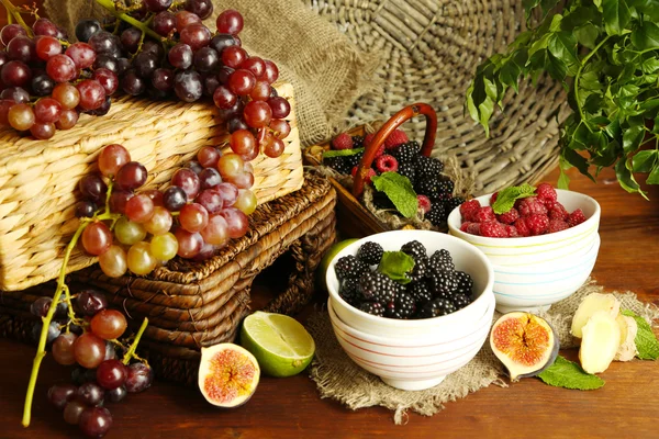 Assortment of juicy fruits and berries on wooden background Royalty Free Stock Photos