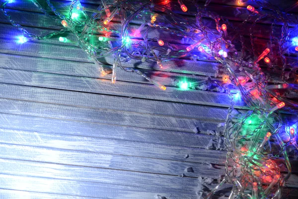 Christmas lights on wooden background — Stock Photo, Image