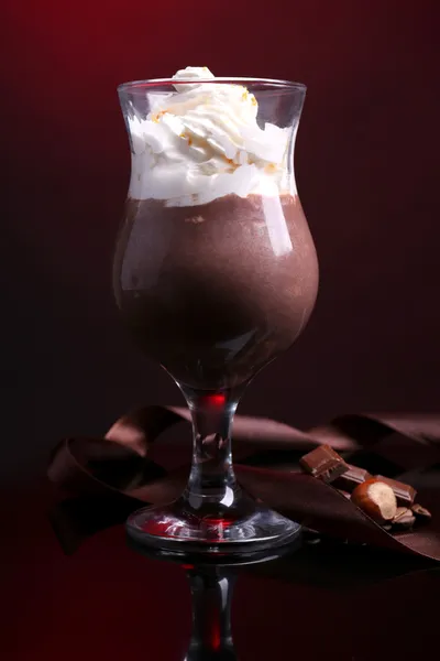 Tasty dessert with chocolate, cream and orange sauce, on dark color background — Stock Photo, Image