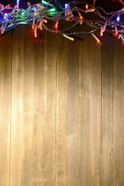 Christmas lights on wooden background — Stock Photo, Image