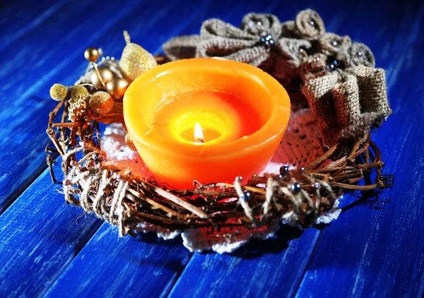 Vela ardiente con decoraciones navideñas sobre fondo de madera de color — Foto de Stock