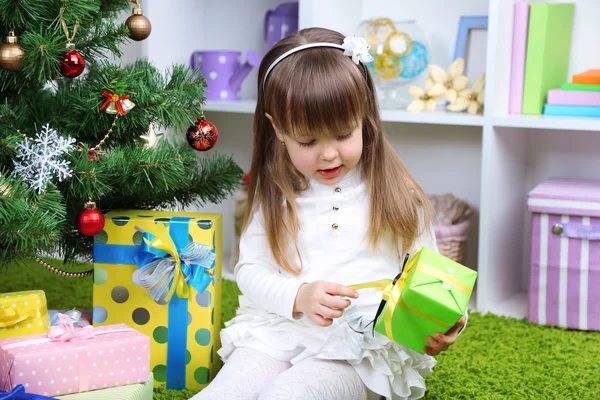 Dziewczynka z obecnym polu w pobliżu choinki w pokoju — Zdjęcie stockowe