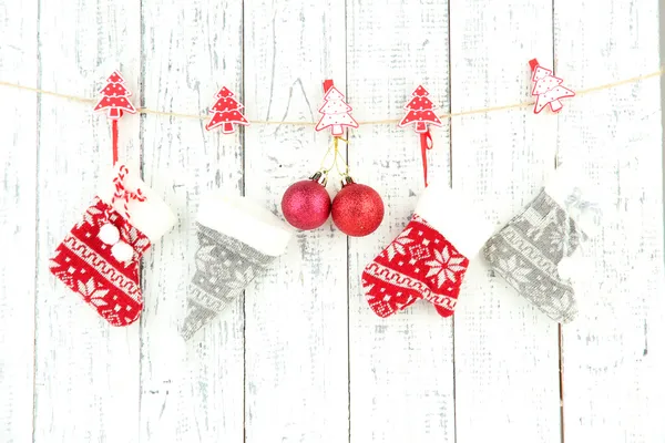 Weihnachtsaccessoires hängen an weißer Holzwand — Stockfoto