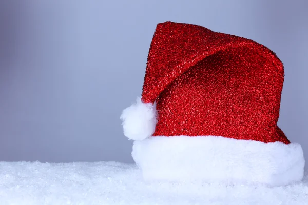 Santa hat on snow on grey background — Stock Photo, Image