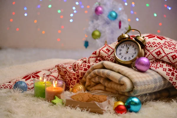 Composition avec plaids, bougies et décorations de Noël, sur tapis blanc sur fond lumineux — Photo