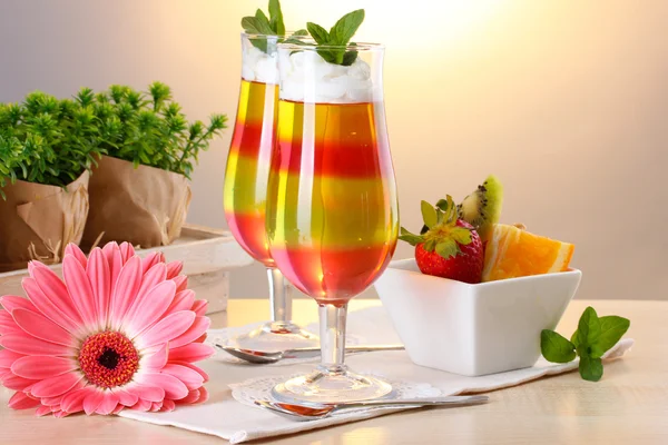 Fruit jelly in glasses and fruits on table in cafe — Stock Photo, Image