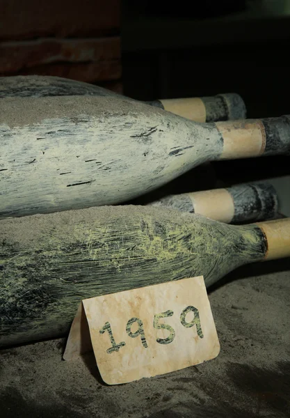 Viejas botellas de vino en bodega vieja, sobre fondo oscuro — Foto de Stock