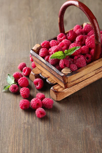 Ripe sweet raspberries in basket on wooden background — Stock Photo, Image