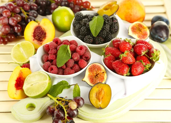 Surtido de frutas y bayas jugosas sobre fondo de madera —  Fotos de Stock