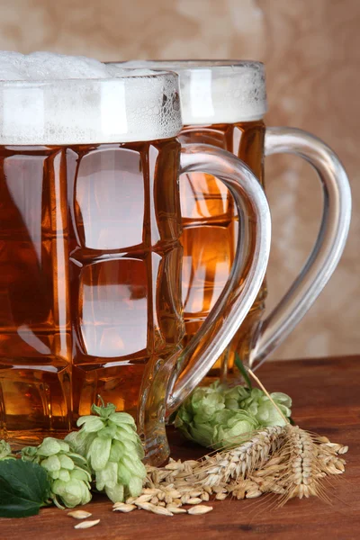 Verres de bière et houblon, sur table en bois — Photo