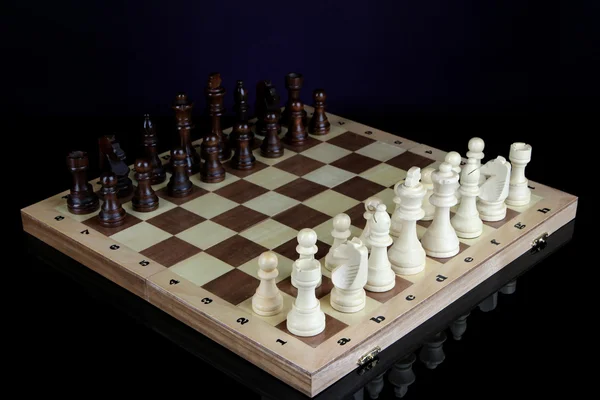 Schaakbord met schaakstukken geïsoleerd op zwart — Stockfoto