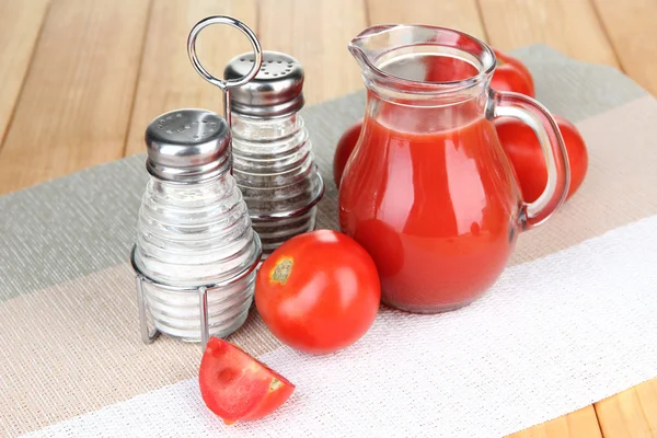 Tomatensap in glazen kan, op houten achtergrond — Stockfoto