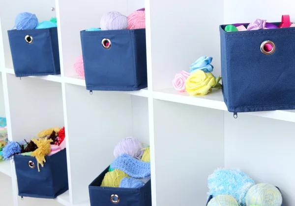 Blaue Textilboxen mit Garn in weißen Regalen — Stockfoto