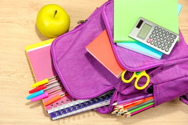 紫色背包和学校用品木制背景 — 图库照片