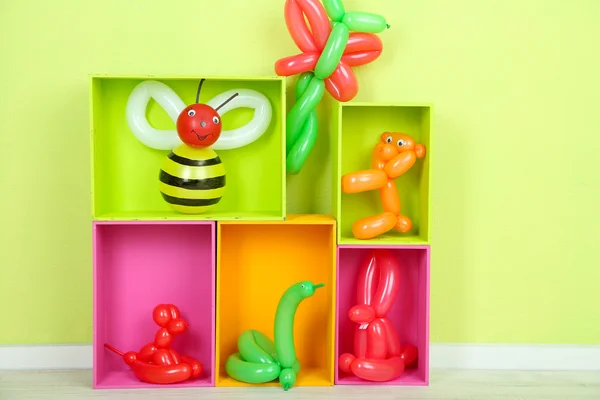 Enkel ballong djur och andra leksaker på hyllor, på ljus bakgrund — Stockfoto