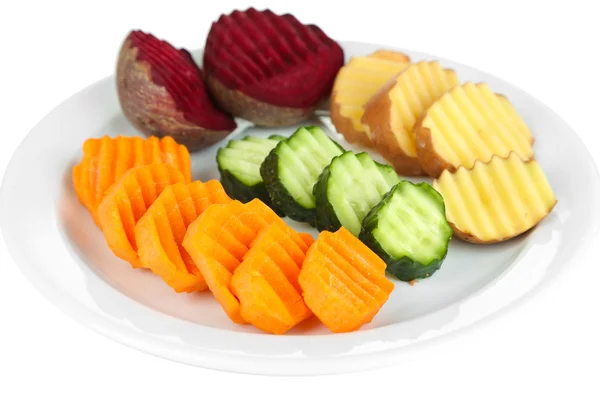 Beaux légumes tranchés sur assiette, isolés sur blanc — Photo