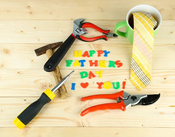 Feliz Día del Padre (imagen conceptual con letras y herramientas multicolores, sobre fondo de madera ) — Foto de Stock