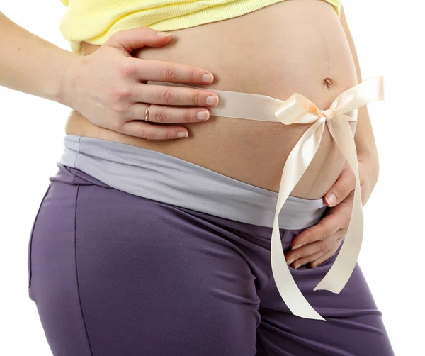 Pregnant young woman with beige bow on belly isolated on white — Stock Photo, Image