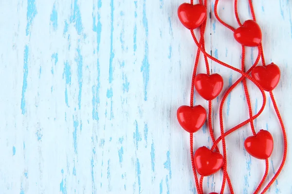 Hjärtformade pärlor på snöre på trä bakgrund — Stockfoto