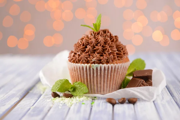 Välsmakande cupcake med smörkräm, på trä färgtabell på ljus bakgrund — Stockfoto